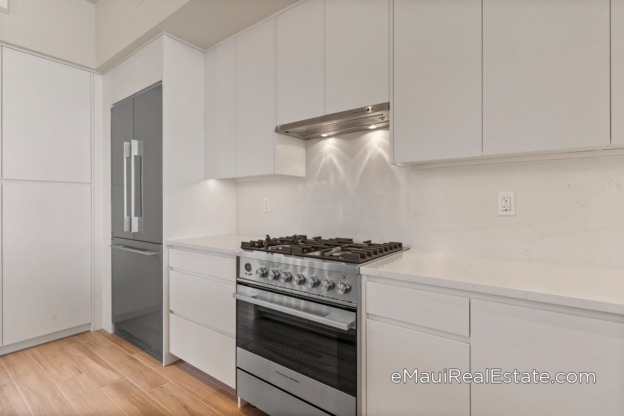 This Makalii unit has multiple  upgrades including custom cabinet panels with beveled edges (white satin lacquer) and polished quartz stone backsplash